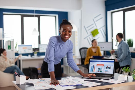 African compnay leadership and corporate entrepreneur looking at camera. Diverse team of business people analyzing company financial reports from computer.