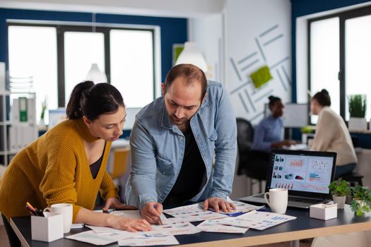 Start up multiethnic management working on charts statistics in office. Diverse team of business people analyzing company financial reports from computer.