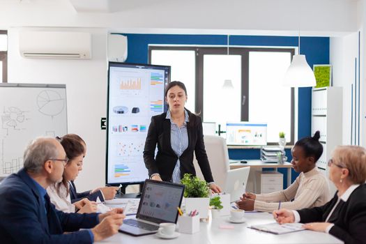 Angry entrepreneur in conference room screaming at coworkers in conference room. Businesswoman raging about multitasking difficult job, screaming in boardroom