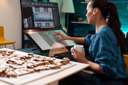 Architectural designer doing engineering sketch using touchpad screen technology monitor computer at design workplace. Caucasian woman working on building plan for renovation project