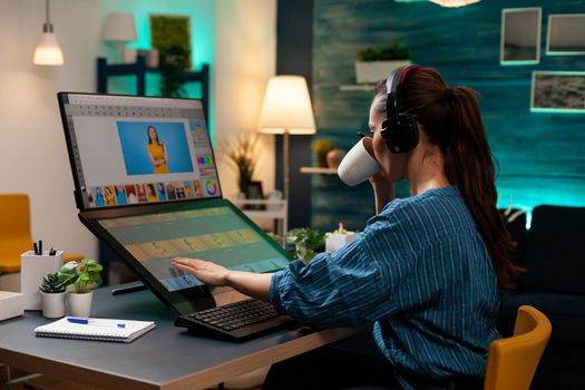 Woman with editor occupation wearing headphones at studio office desk. Professional graphic artist working on picture editing background for template using touchpad monitor screen