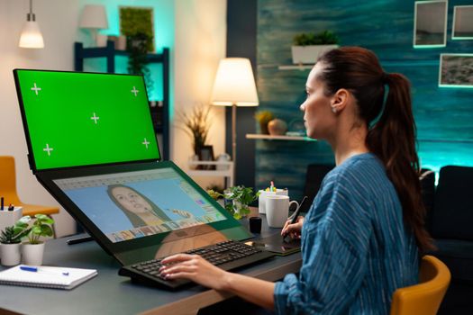 Media project artist working with green screen on display computer monitor at photography studio. Woman using retoucher and chroma key for mockup template background at creative workplace