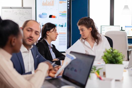 Women in startup office having a conversation in conference meeting room. Businesswoman discussing ideas with colleagues about financial strategy for new start up company.