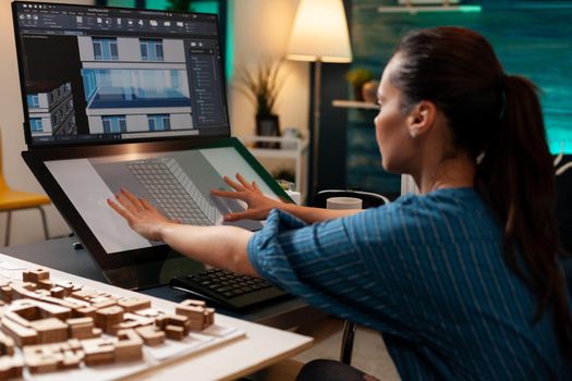 Modern architect designing building model sketch blueprint plan for future business renovation construction concept. Caucasian woman using professional touchpad screen on computer monitor