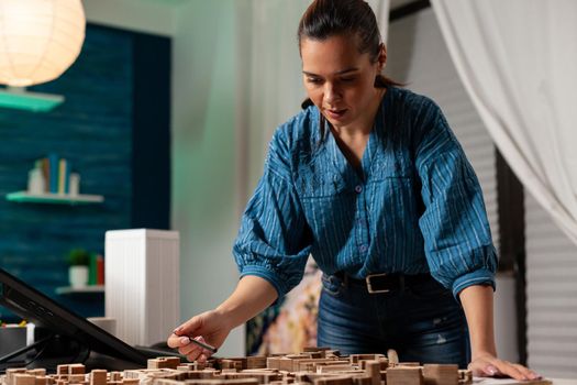 Caucasian worker standing at business desk office doing architectural design project for futuristic development construction. Professional woman working on maquette for renovation concept