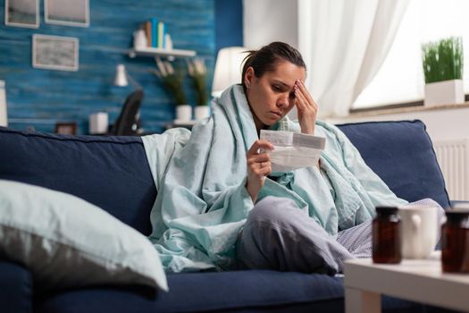 Sick person holding pharmaceutical prescription from doctor as treatment of illness disease. Caucasian young adult taking medication from pharmacy to cure pain headache.