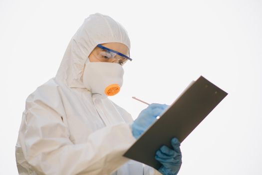 Worker in chemical protective suit. Successful chemist in a suit posing on a white background isolated. Doctor epidemiologist fighting with coronavirus COVID-19.