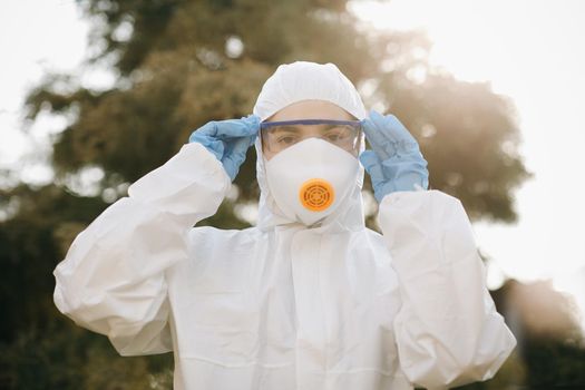 Portrait of doctor epidemiologist fighting with coronavirus COVID-19. Protection mers by virologist. White medical suit with mask, gloves, glasses. Face of global crisis during epidemic