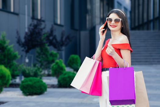 Shopping and tourism concept. Beautiful girl with shopping bags. Shopaholic. Sale and discount.