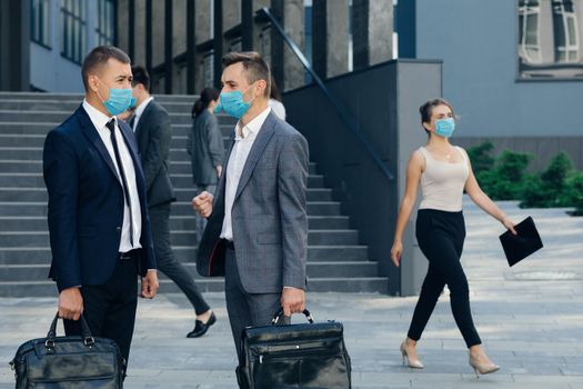 Two Employees Co-workers Manager in Protective Mask Discussing Outside Office Building. Confident Man Explaining Something to Male Colleague.
