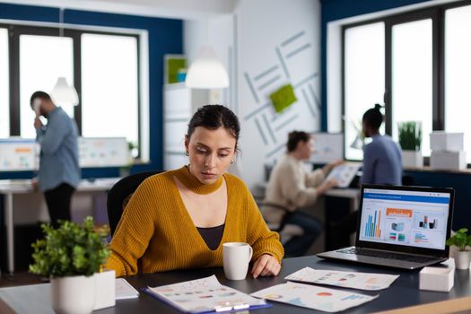 Businesswoman and management team working with company charts on documents. Executive entrepreneur, manager leader sitting working on projects with diverse teamworkers.