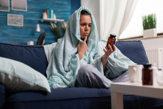 Sick woman taking medical treatment pills drugs antibiotics for illness, holding jar of pharmaceutical medicament. Person with headache having bottle container of painkillers for remedy