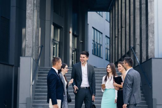 Businessman in suit talking to business people colleagues or partner. Male leader discussing work at team meeting or group negotiations having conversation