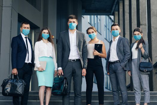 Corporate team portrait in Protective Mask. Professional business people in Protective Mask look at camera standing outside business center