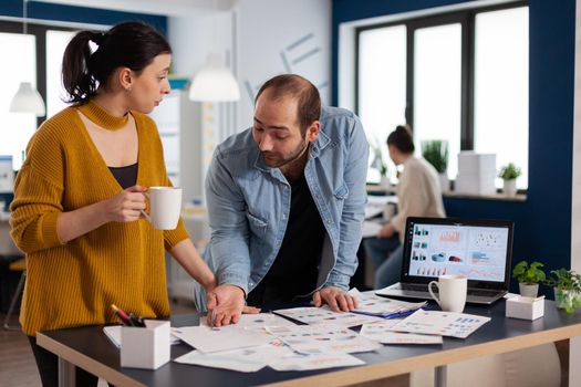 Company leadership during briefing talking looking at marketing statistics charts. Diverse team of business people analyzing company financial reports from computer. Successful start up corporate professional entrepreneur online internet statistics