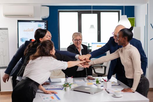 Happy creative multiethnic business team celebrating successful project. Diverse colleagues with new opportunity enjoing victory meeting in broadroom office.