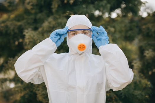 Portrait of doctor epidemiologist fighting with coronavirus COVID-19. Protection mers by virologist. White medical suit with mask, gloves, glasses. Face of global crisis during epidemic.