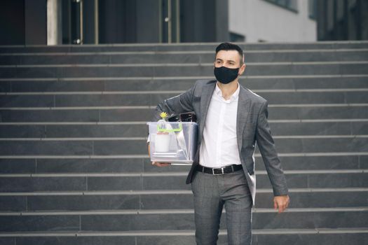 Fired man walking outdoor. Depressed jobless person. Unemployment concept. Left without money. Sad male office worker in depression with box of personal stuff. Businessman lost job.