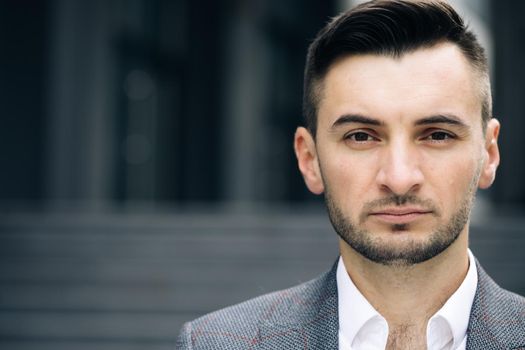 Portrait of handsome nice entrepreneur in formal suit standing outside work. Successful businessman. Corporate people. Office manager. Businessman standing look at camera near business center