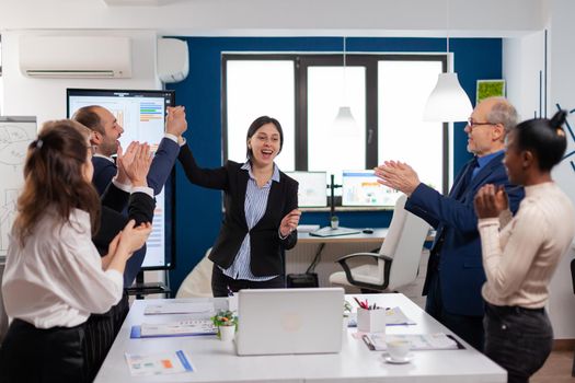 Corporate business team achieving success concept for startup in conference room victory, winners. Multiethnical partners coworkers celebrate successful teamwork result at company briefing