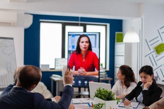 Young man listening coach during online video call in conference room. Business people talking to webcam, do online conference participate internet brainstorming, distance office discussion