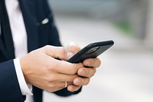 Businessman working on the smartphone. Close up of a man using mobile smart phone.