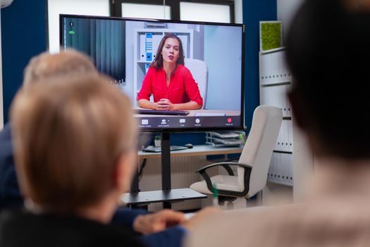 Diverse business team having videomeeting discussing online with remotely executive manager in business office. Business people talking to webcam, do online conference participate internet brainstorming, distance office discussion.