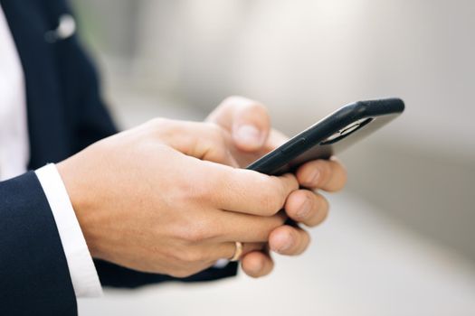 Close up of a man using mobile smart phone. Businessman working on the smartphone.