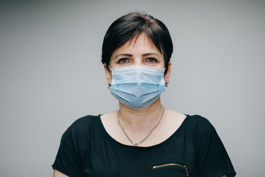 Woman Wearing Medical Mask During Coronavirus COVID-19 Epidemic. Sick woman wearing protection during pandemic. Pretty Caucasian Woman Taking on Medical Mask.