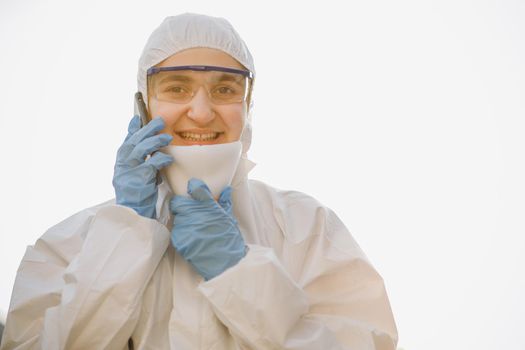 Medical worker portrait, Confident Asian doctor in protective PPE suit wearing face mask and eyeglasses. Worker in chemical protective suit on a white background