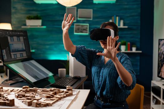 Professional architect using vr glasses for building vision hologram on 3d interactive technology at office workplace. Construction engineer woman designing creative digital simulation