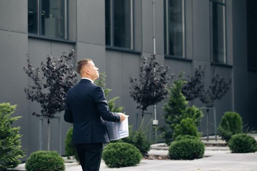 Excited man trainee new employee on first day at work carrying box with stuff to his new workplace. Concept of work,career and success