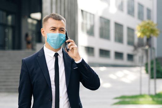 Caucasian young businessman in medical mask talking on phone. COVID-19 Coronavirus Infection. Face mask Covid-19. Epidemic Coronavirus Mers. Human Masked 2019-ncov.