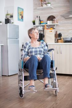 Sad depressed disabled senior woman sitting in a wheelchair. Elderly handicapped pensioner after injury and rehab, paralysis and disability for depressed invalid full of sorrow, worry and sad face. Retirement period for old people