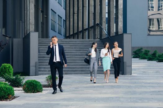 Handsome Businessman Wearing Suit Talking on the Phone Walking near Bussiness Centre. Successful Business. Wearing Classical Suit. Social Network. Apps. Smartphones.