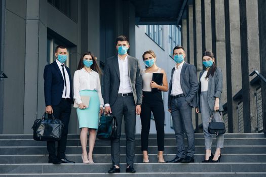 Corporate team portrait in Protective Mask. Professional business people in Protective Mask look at camera standing outside business center