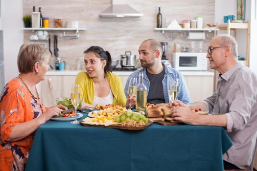 Family sitting at dining table. Mother and daughter having a conversation during lunch. Tasty seasoned potatoes.