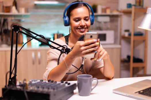 New media star using smartphone in home studio and recording vlog. Creative online show On-air production internet broadcast host streaming live content, recording digital social media communication