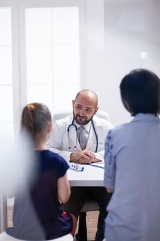 Doctor changing the kid treatment after the consultation in hospital office. Healthcare physician specialist in medicine providing health care services treatment examination.