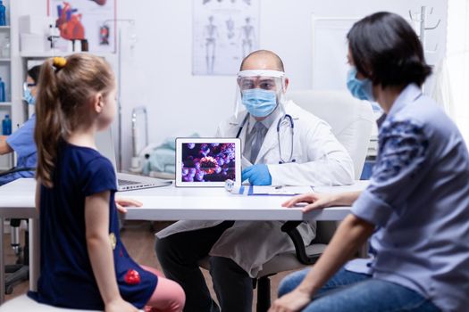 Doctor explaining about coronavirus to mother and child during consultation. Pediatrician specialist providing health care service radiographic treatment examination.