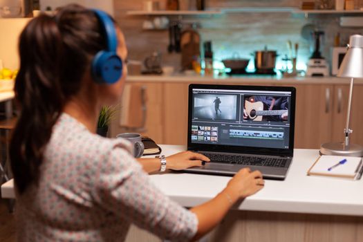 Young sound engineer working on video footage during post production. Content creator in home working on montage of film using modern software for editing late at night.