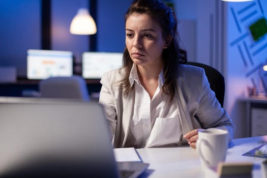 Pov of businesswoman looking in camera during online videocall conference, talking with teamates for rise profit. Manager analysing marketing statistics late at night in business office