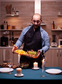 Boyfriend preparing romantic dinner for wife in kitchen. Man preparing festive dinner with healthy food, cooking for his woman a romantic dinner,