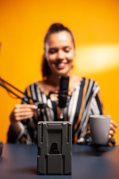 Close up of battery with v-lock mount while recording professional review. Professional videography gear review by content creator new media star influencer on social media.