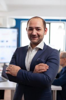 Young man entrepreneur smiling in front of camera standing in brainstorming room, preparing for meeting with partners. Manager working in professional start up financial business, modern company workplace ready for meeting.