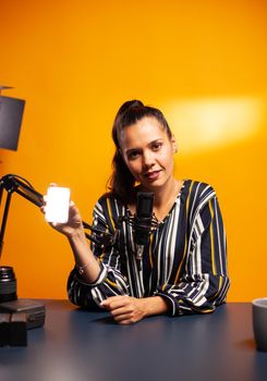 Content creator holding mini led and talking about during podcast. Video blogger recording a vlog with technology product equipment use in videography and photography
