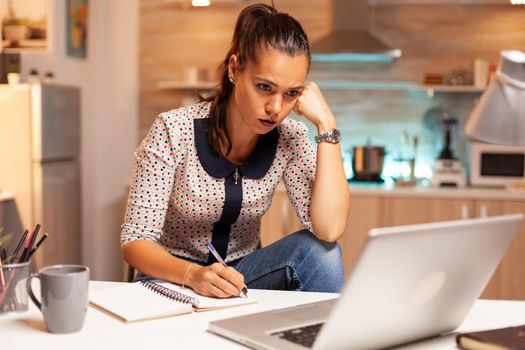 Concentrated businesswoman trying to finish a project for work during midnight. Employee using modern technology at midnight doing overtime for job, business, busy, career, network, lifestyle ,wireless.