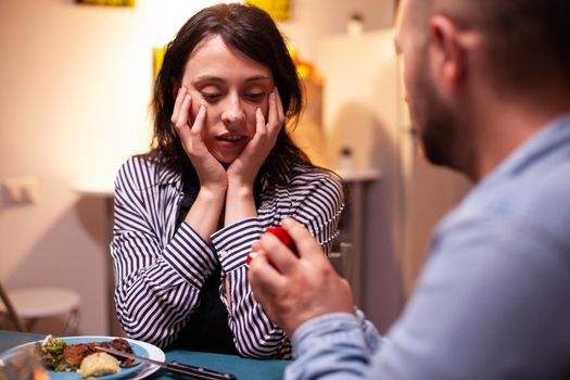 Woman looking shocked during marriage proposal while having dinner. Romantic happy caucasian woman smiling being speechless, excited, smiling, fiance, romance.