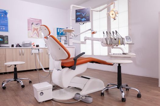 Empty orthodontist stomatology office with nobody in it. Light modern equipped orthodontic workplace, teeth hygiene and care. Hospital dental health. Tooth xray image on monitor