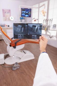 Specialist radiologist holding medical teeth radiography in hands examining teethcare surgery expertise. Orthodontist doctor working in stomatology dental orthodontic hospital office room